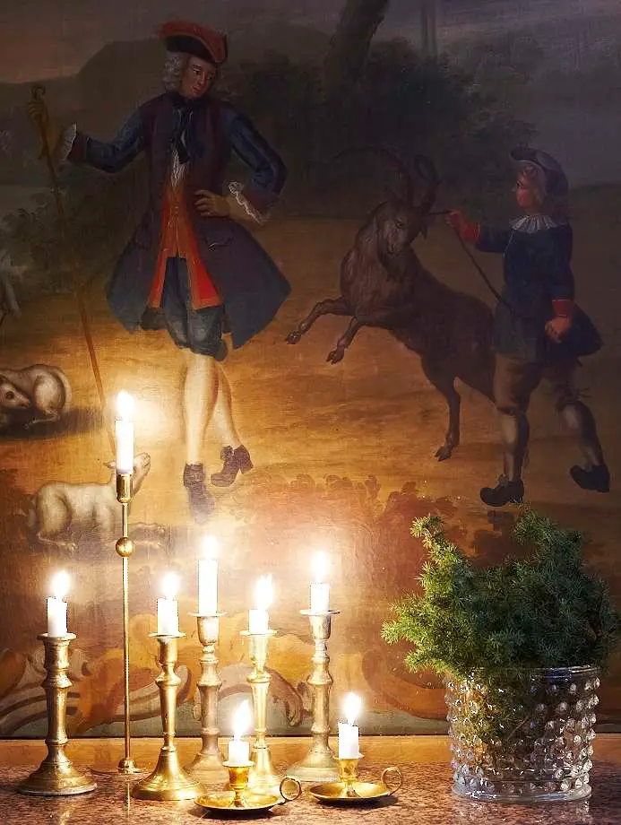 Mässingsljusstakar framför en stor målning, Pontus Nilvanders hem i juletid