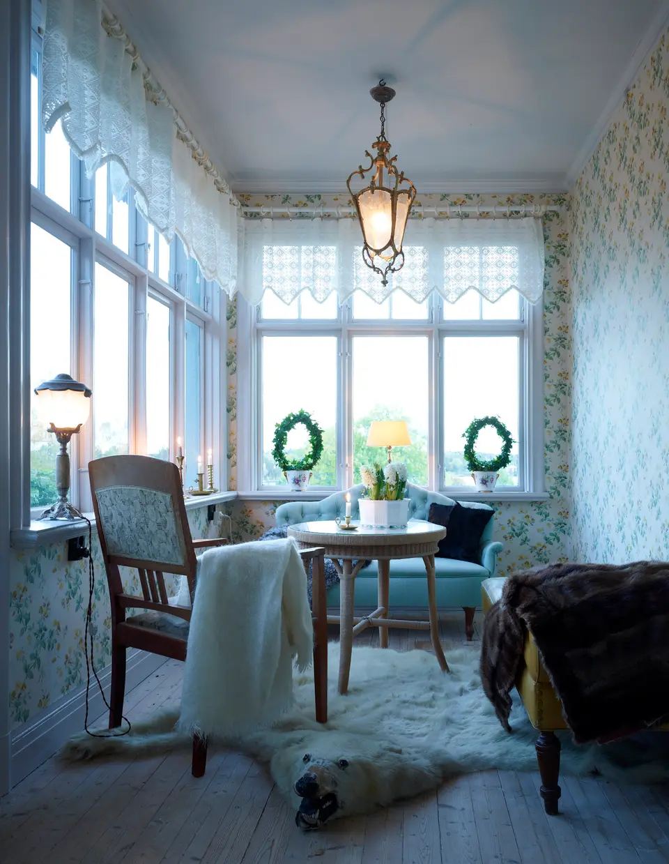 Glasveranda med spetsgardiner, lykta och fäll, skärgårdshus på Yxlan