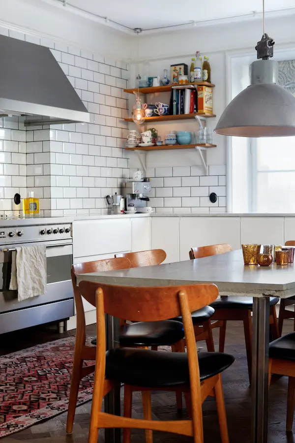 Bistrokök med vitt kakel, öppna hyllor och trästolar, våningen Dusty Deco