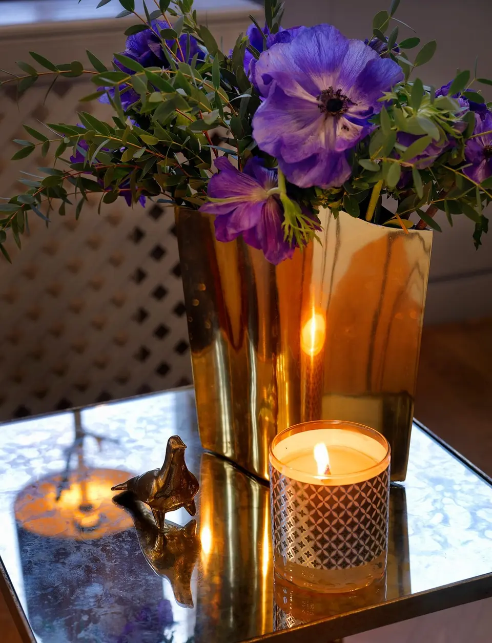 Lila anemoner i en vas av mässing och ett doftljus, Alexandra Pascalidous hem i Stockholm