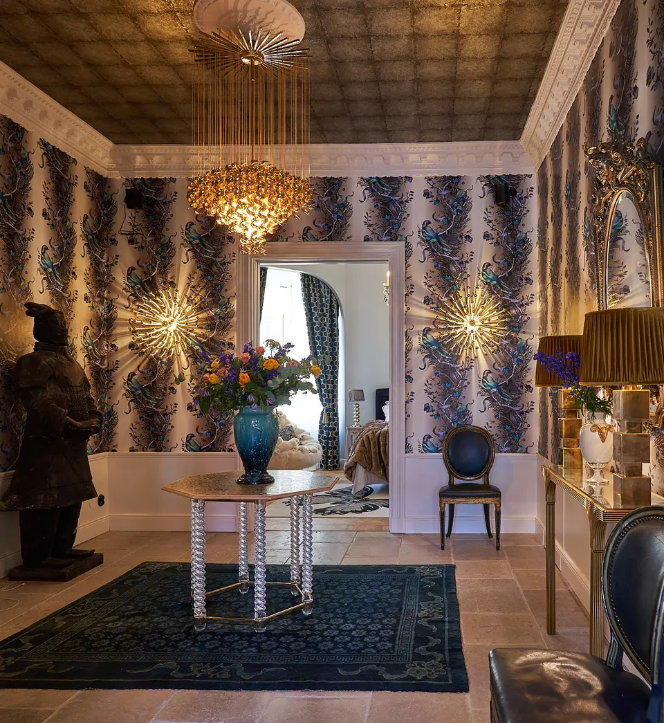 Hall med strålande vägglampor, kristallkrona och mönstrat plåttak, sekelskiftesvåning på Grevgatan, Östermalm