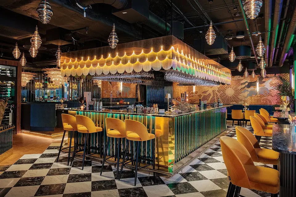 Art deco-bar med schackrutigt marmorgolv, gula barstolar och glasljuskronor, Restaurang Pava, Stockholm