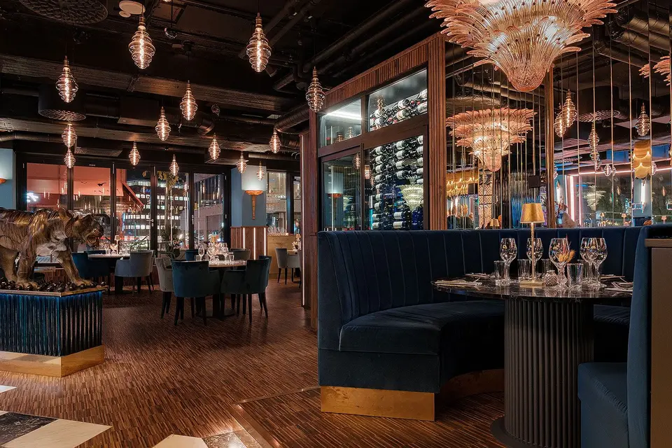 Soffbås i blå sammet under en glasljuskrona, Restaurang Pava, Stockholm
