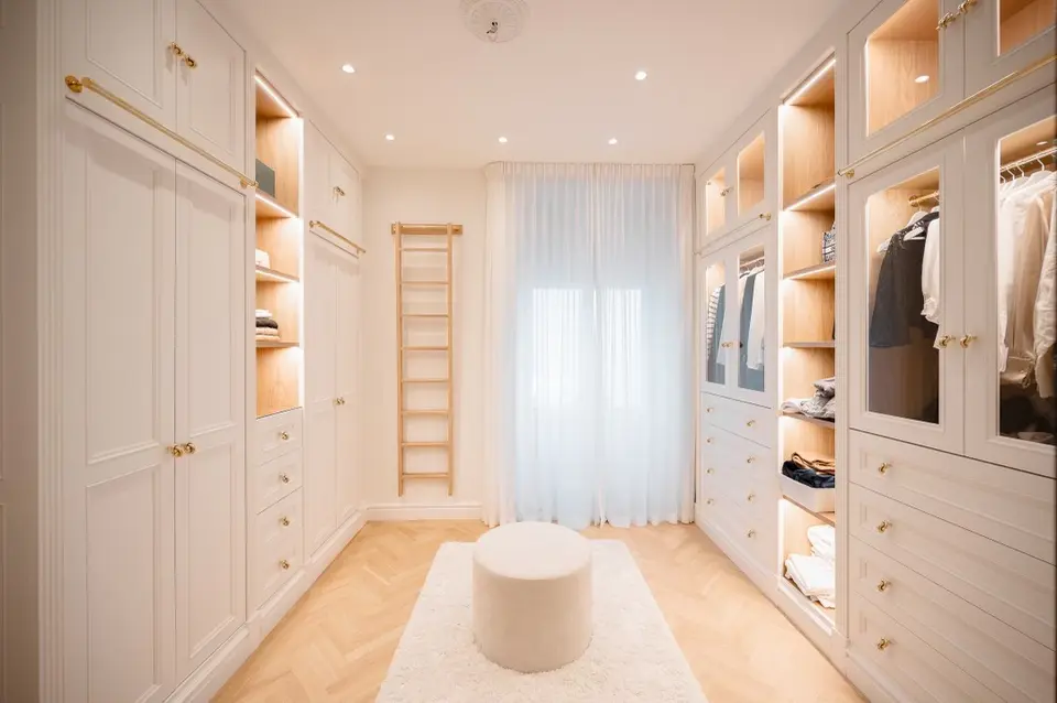Walk-in closet med garderober, belysta hyllor, pall och stege, våning på Strandvägen, Östermalm